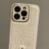 Pearl Charm Leather iPhone Case – Embossed Floral Design & Elegant Wrist Strap